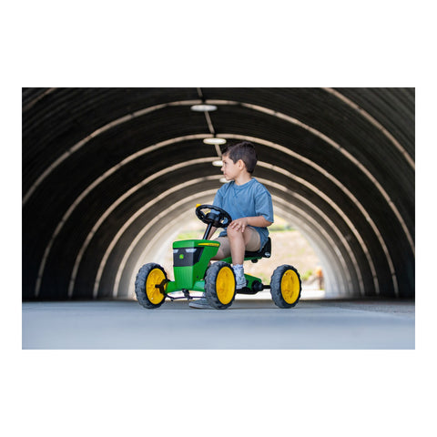 Child riding a BERG Buzzy John Deere pedal kart